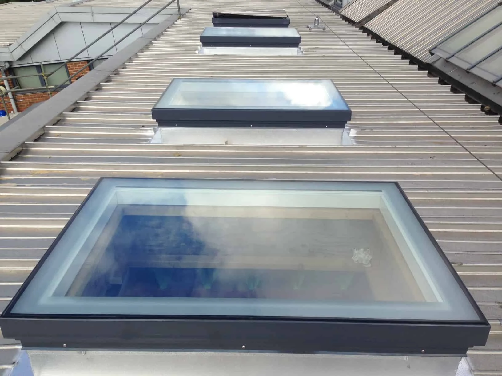 Three flat roof windows on a building.