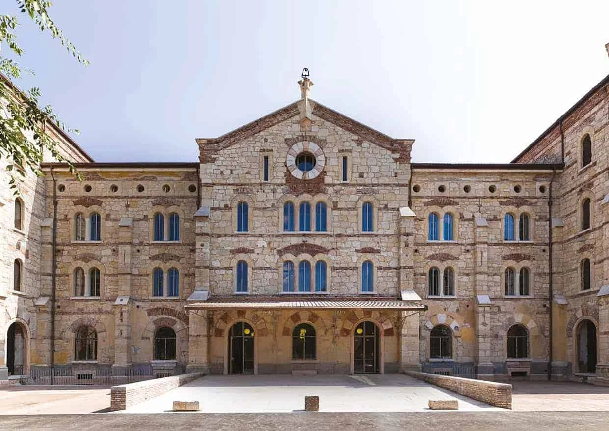 A large stone building with OTTOSTUMM Steel Windows and a courtyard.