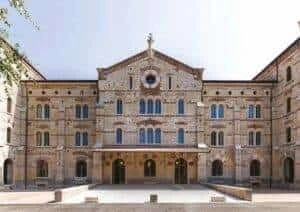 A large stone building with OTTOSTUMM Steel Windows and a courtyard.